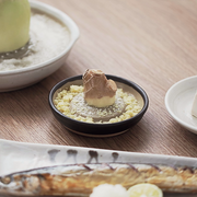 Ceramic Japanese grater being rinsed clean under running water.

