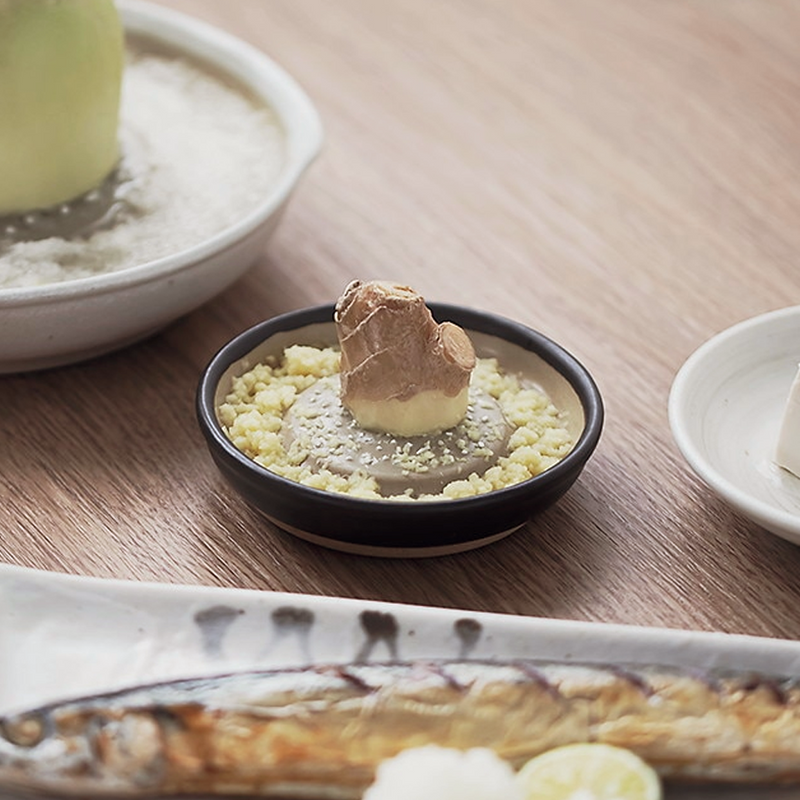 Ceramic Japanese grater being rinsed clean under running water.

