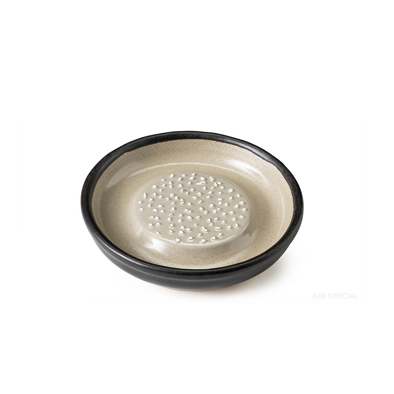 A clean, empty Japanese ceramic grater plate with raised teeth in the centre.

