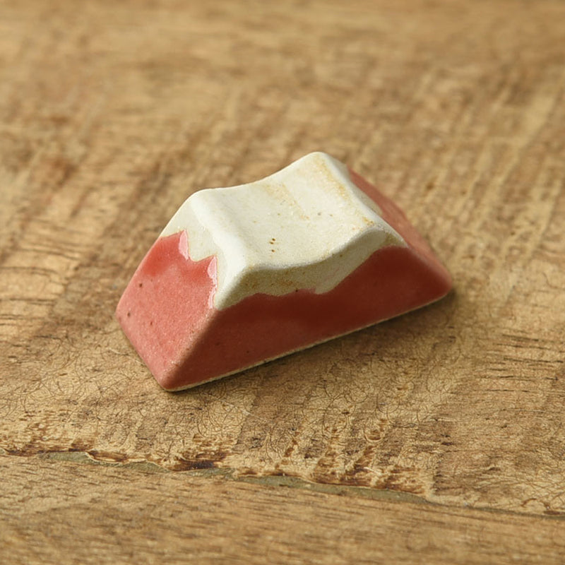 Close-up of the red Mount Fuji chopstick rest showing the white glazed peak
