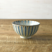 Mugiwara Pattern Japanese Rice Bowl featuring vertical blue brushstrokes with rust-coloured tips on a white ceramic base.