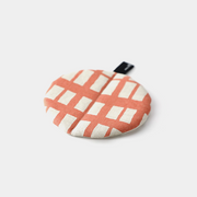 The &NE Manmaru Pot Holder and Table Mat, a round, flat fabric trivet with a modern coral and white pattern.

