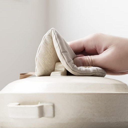 A flat lay of the round &NE Manmaru Pot Holder in Natural Beige, showing the central stitching line, logo tag, and hanging loop.