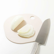Sliced onion on a cutting board with a knife on a white background