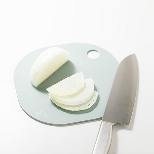 &NE Nikii Mini Antibacterial Cutting Board in a soft green colour, being used to slice white onions.