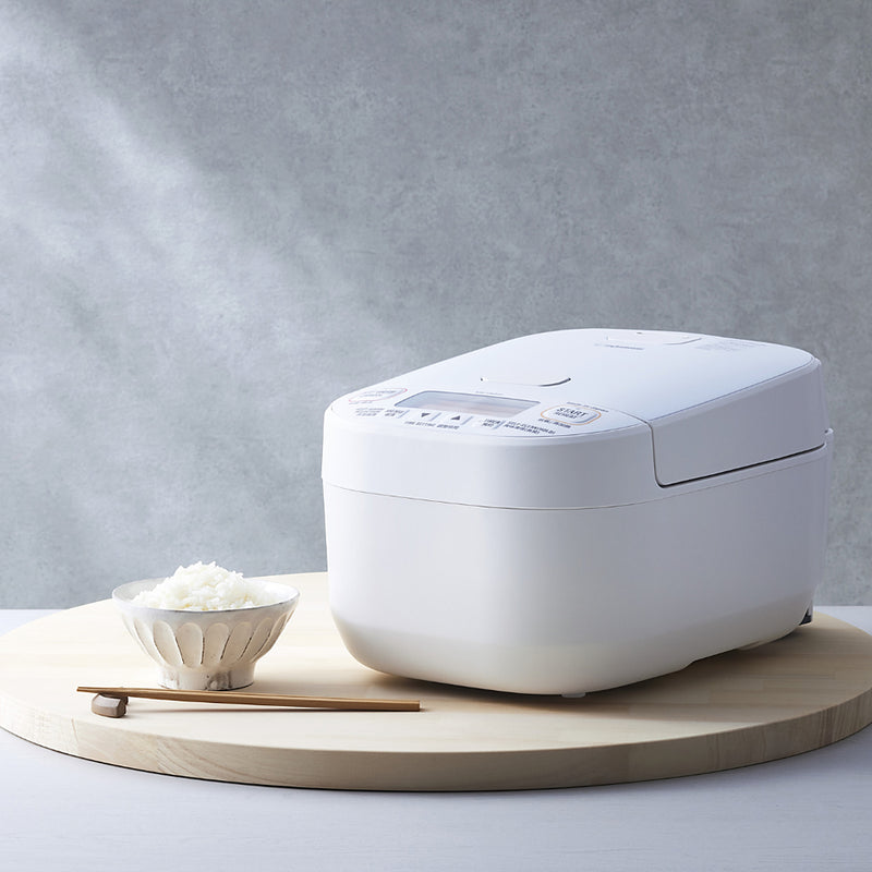 Zojirushi NW-YAQ10 Pressure IH Rice Cooker 5.5 Cups in white with a bowl of cooked rice