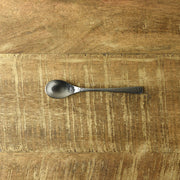 Nagomi hammered coffee spoon lying flat on a wooden table