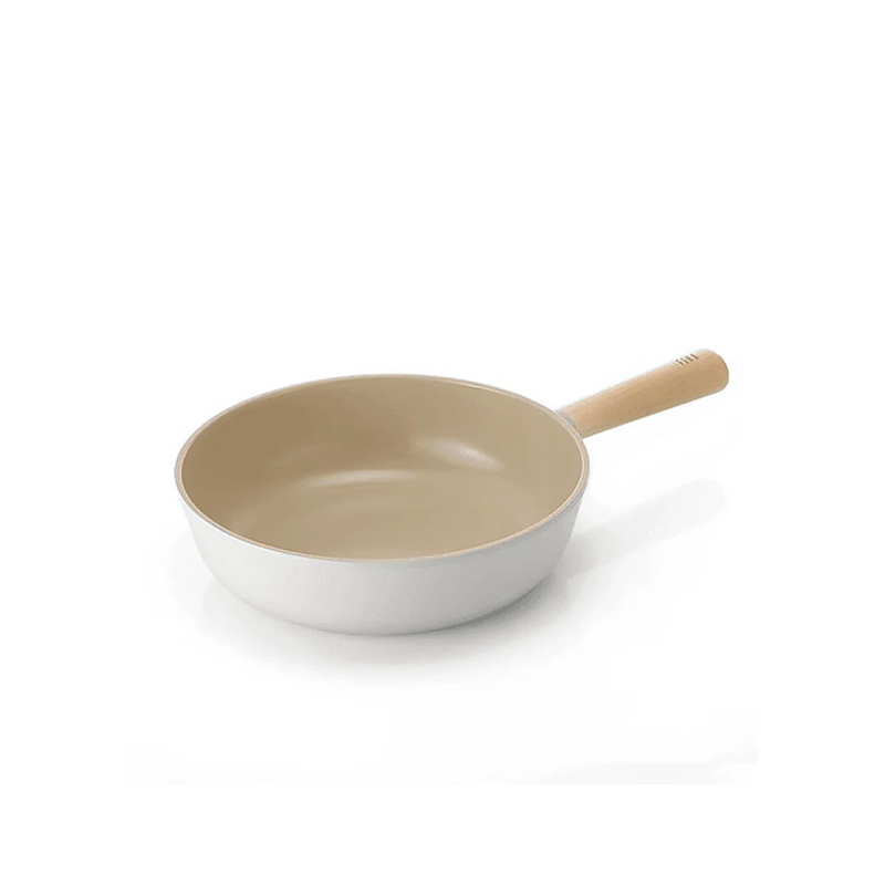 Neoflam Fika 26cm ceramic nonstick wok in a light cream colour with a wooden handle, shown on a clean white background.
