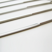 A close-up view of the flat profile of the Nippan barbecue skewers, showing the sturdy steel design that prevents food from spinning during grilling.