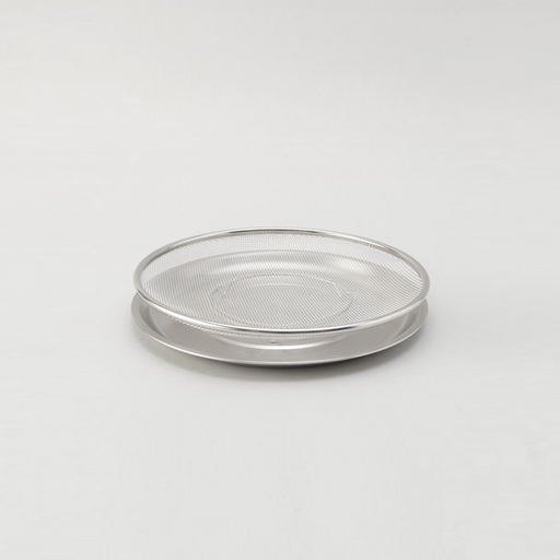 The two-piece Ryoumiya stainless steel set, featuring a round fine-mesh strainer resting neatly on top of its matching solid serving tray.