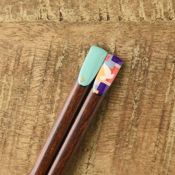 Wooden chopsticks from the Retro Vintage Series - Canary design, featuring a mint green lacquered tip paired with a colourful dove mosaic pattern, elegantly displayed on a rustic wooden surface.