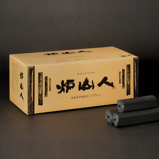 Rosanjin A premium Japanese Ogatan charcoal cardboard box with traditional calligraphy next to three pieces of compressed hexagonal sawdust charcoal