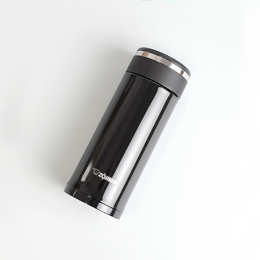 A glossy black Zojirushi SM-JD36 vacuum insulated flask with a screw-top lid lying diagonally on a white background.
