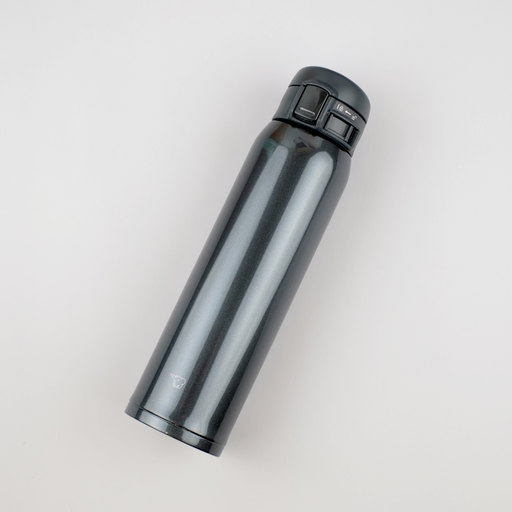 A sleek black Zojirushi SM-SR60E vacuum insulated flask with a one-touch open lid lying diagonally on a white background.