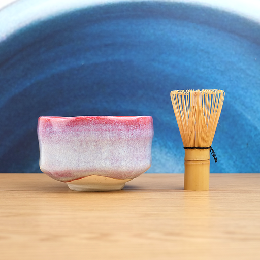 The Sakura Unofu matcha bowl (chawan), featuring a speckled pink and light blue glaze and an irregular rim, shown against a light grey background. Made in Japan
