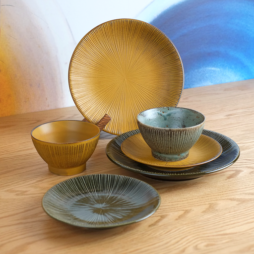 The Sendan Kurawanka 6-piece dinnerware set, showing two large plates, two small plates, and two bowls in green and mustard with a radiating line pattern.