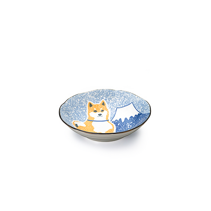 Isolated image of a shallow ceramic bowl with a Shiba Inu and Mount Fuji design on a speckled blue background, emphasizing the irregular rim and artistic style.