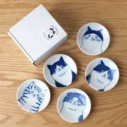 A set of five Shichita Mino Yaki cat mini plates arranged on a wooden surface next to their white product box.
