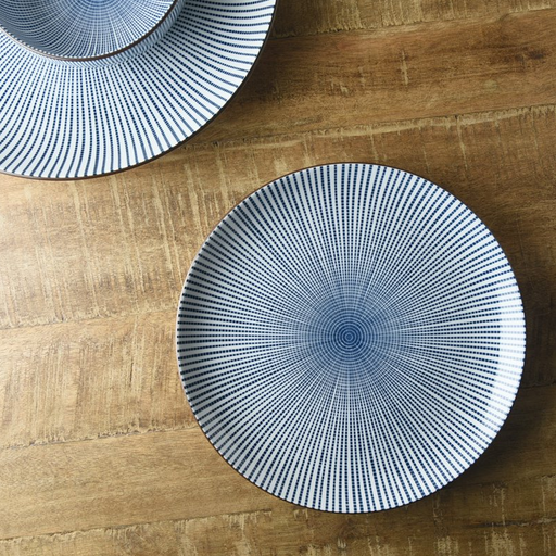 Two Showa Seito Sendan Tokusa porcelain plates with blue and white radial patterns, displayed on a wooden table surface.