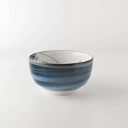 A side-profile view of the Showa Seito 'The Great Wave' bowl, showing the blue banded glaze on the exterior and the artwork on the interior.