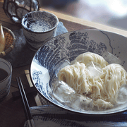 A lifestyle photo showing the versatility of the Great Wave bowl, used here to serve a dish of chilled noodles with ice.