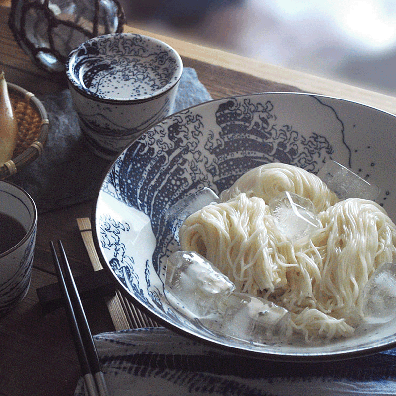 A lifestyle photo showing the versatility of the Great Wave bowl, used here to serve a dish of chilled noodles with ice.
