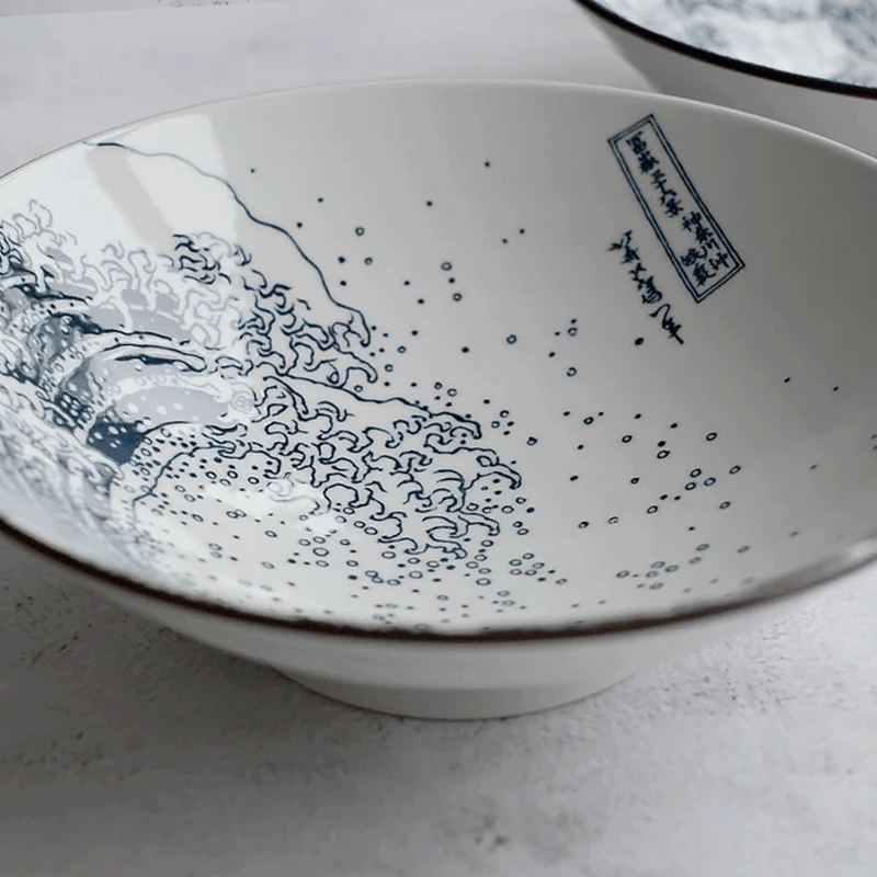 A close-up detail shot of the interior of 'The Great Wave' ramen bowl, showing the fine blue lines of the ukiyo-e print and the artist's cartouche.







