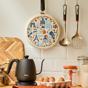 The T-fal crepe pan hanging in a stylish kitchen, showcasing its decorative Parisian-themed base as a design feature.