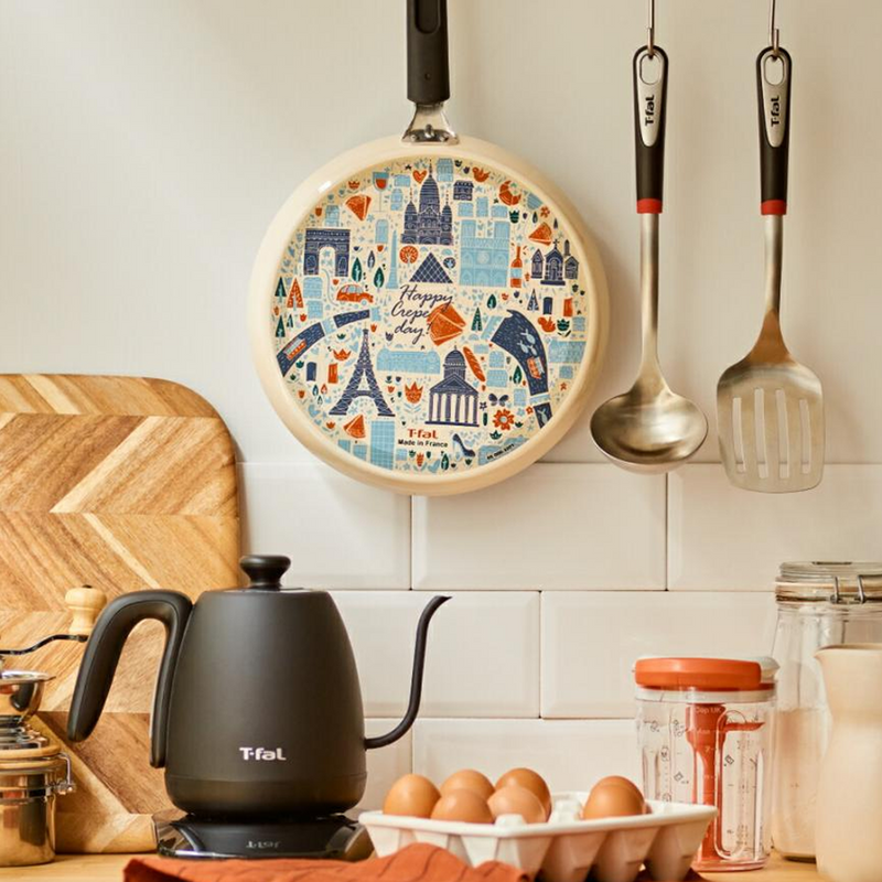The T-fal crepe pan hanging in a stylish kitchen, showcasing its decorative Parisian-themed base as a design feature.