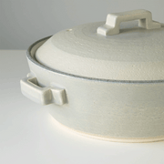 Bird's-eye view of the Tojiki Tonya Tstyle Donabe Japanese clay pot, emphasizing its smooth, silver-grey surface and central lid handle.