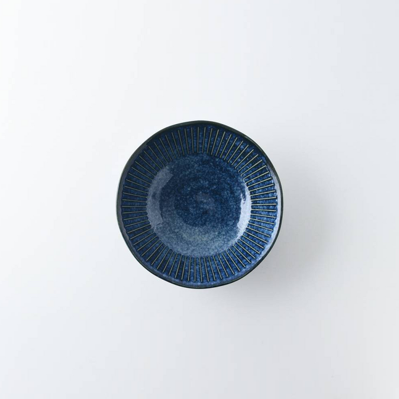 A top-down product shot of the Tokusa Indigo Bowl, showcasing the full radiating pinstripe pattern and deep blue glaze.

