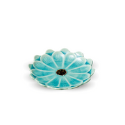 A top-down view of the Touga Daisy Side Plate, showing its vibrant teal colour, flower-petal shape, crackle glaze, and dark, textured center.