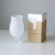 Frosted tulip beer glass next to its packaging, which has minimalist Japanese branding and a natural-toned design.
