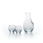 The Toyo Sasaki handmade clear glass sake set, featuring a rippled texture carafe and two matching small cups, shown together against a white background.
