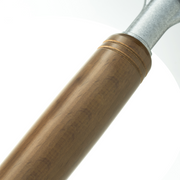Close-up of a wooden handle on a black wok, showing the grain of the wood and the metal attachment with rivets on a white background.