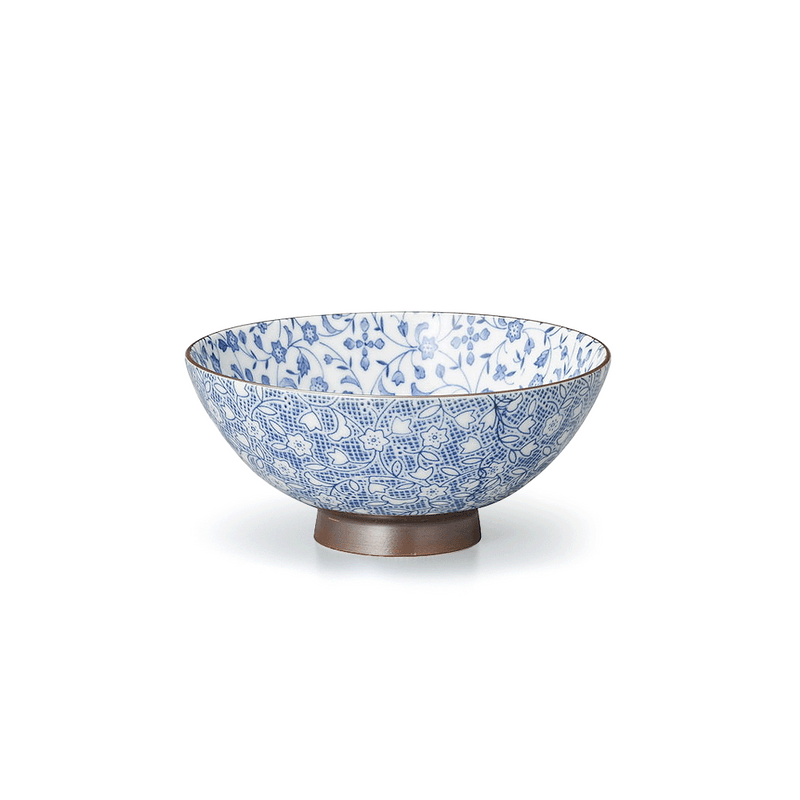 A side view of the Tsuru Karakusa Fukamaru Japanese Bowl, showing its intricate blue and white floral pattern and contrasting brown footed base.