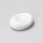 A white porcelain chopstick rest with a smooth, organic bean shape, shown on a plain background.