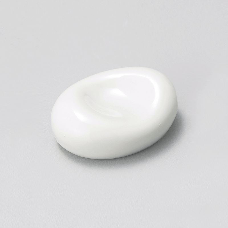 A white porcelain chopstick rest with a smooth, organic bean shape, shown on a plain background.