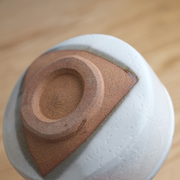 A close-up of the unglazed clay foot of the Yamaman Kohiki matcha bowl, showing the spiral pattern left by the potter's wheel.
