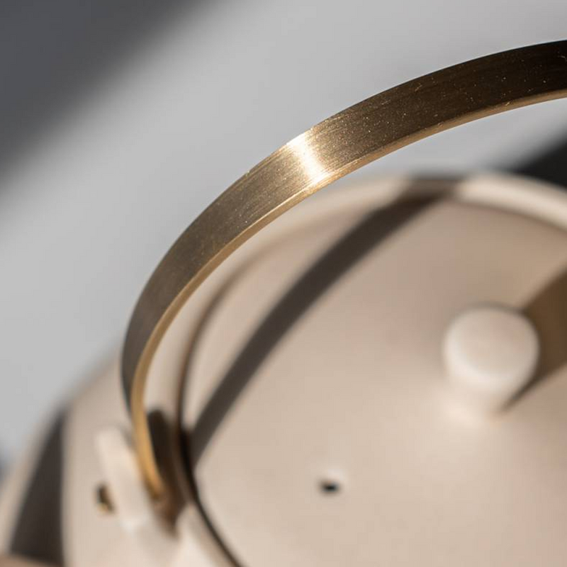 Close-up of the brass handle on the Yamatsu Frustum teapot, highlighting its satin finish and secure attachment point.

