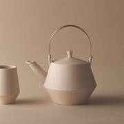 Close-up of the brass handle on the Yamatsu Frustum teapot, highlighting its satin finish and secure attachment point.

