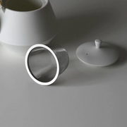 Top view of yamatsu frustum teapot in matte black with brass handle and geometric body.