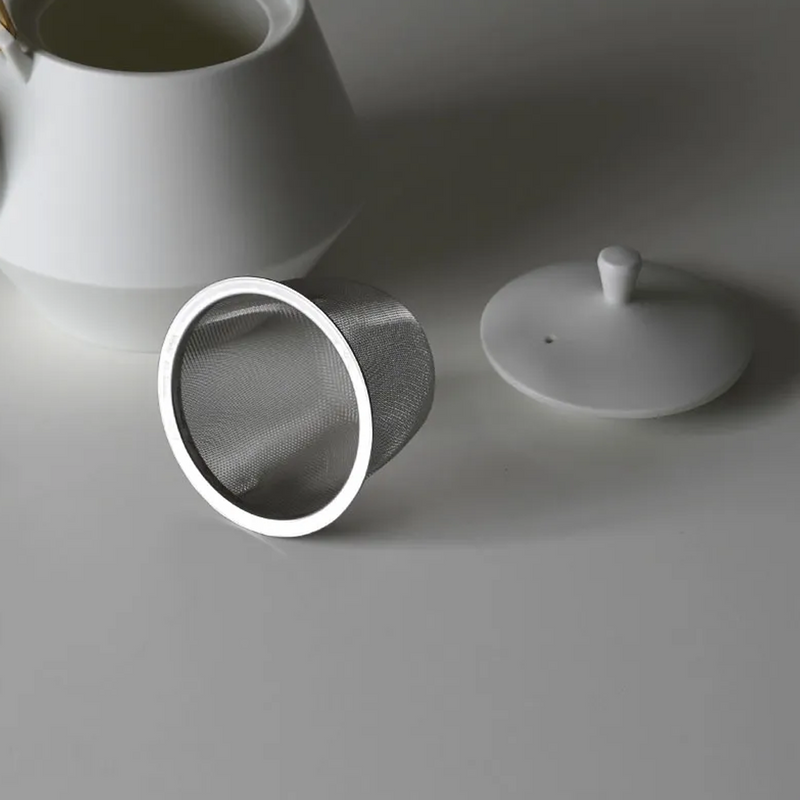 Top view of yamatsu frustum teapot in matte black with brass handle and geometric body.