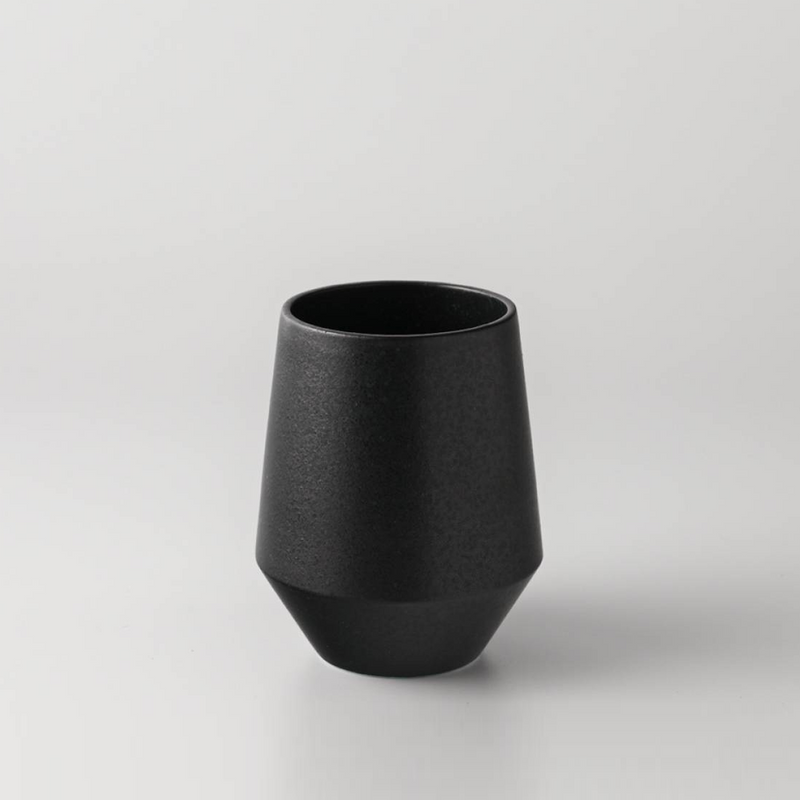 Yamatsu Frustum Japanese teacup in matte black finish, featuring a modern geometric silhouette with a conical base, set against a plain light grey background.







