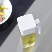 A top-down view of the white Yamazaki Tower condiment dispenser, highlighting its square lid and minimalist aesthetic.

