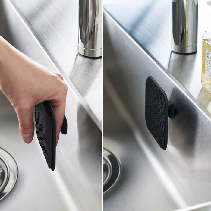 Yamazaki Tower Series silicone sponge attached to a stainless steel sink wall using its magnetic feature.







