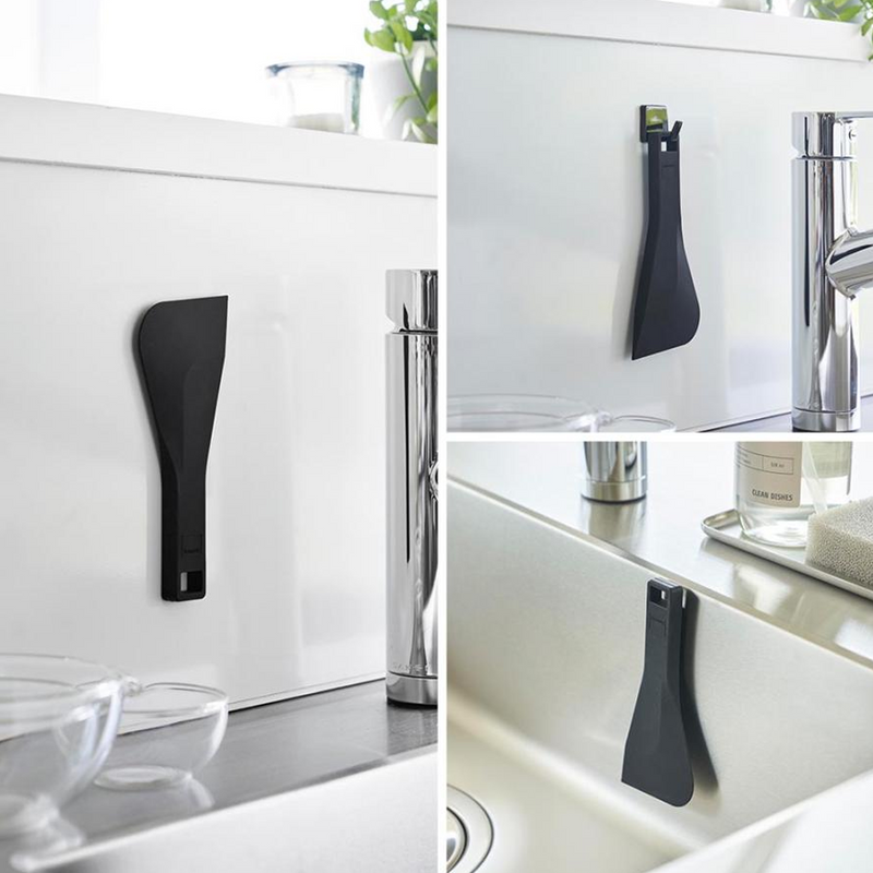 Person cleaning red sauce residue from a nonstick frying pan using the scraper.

