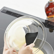 Person cleaning around a gas stove burner with the scraper.

