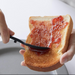 A person using a Yamazaki Tower Series Silicone Scraping Spoon to spread jam on a slice of toasted bread.