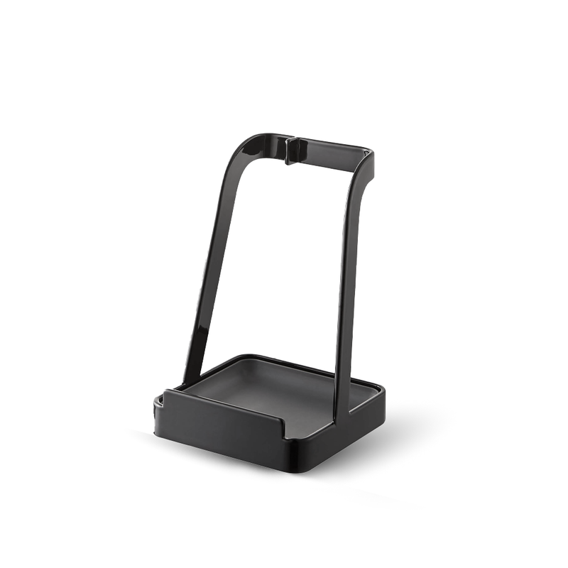 A product image of the black Yamazaki Tower Series Utensil and Lid Stand, showing its minimalist design and drip tray base on a white background.


